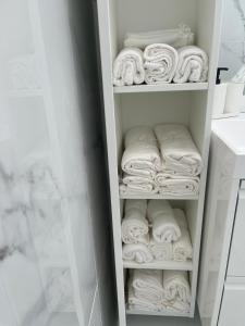 szafę z białymi ręcznikami w łazience w obiekcie grand duplex rénové w mieście Huy