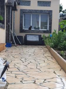 Un patio de piedra frente a una casa con una ventana. en BM PAVILLONS, en Goussainville