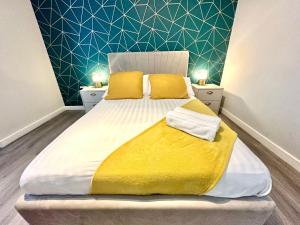 a bedroom with a large bed with yellow pillows at Spacious One Bedroom Apartment - With Parking and WiFi - Town Centre Location - Gated Access - Walk to Beach! in Bournemouth