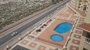 an overhead view of a building with a swimming pool at LA Perla Studio Near The Beach in Ras al Khaimah