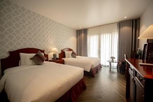 a hotel room with two beds and a window at Khách sạn Sơn Nữ in Bak Kan