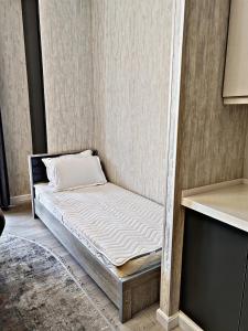 a small bed in a corner of a room at Tashkent city Boulevard 3A-81 in Tashkent +2 photos