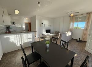 ein Esszimmer und eine Küche mit einem Tisch und Stühlen in der Unterkunft Apartamentos Cap y Corp in Alcossebre