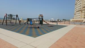 an empty playground with a swing set on the beach at LA Perla Studio Near The Beach in Ras al Khaimah