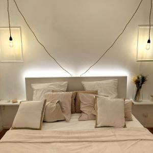 ein Schlafzimmer mit einem großen Bett mit weißer Bettwäsche und Kissen in der Unterkunft Canalisez-vous au Bord du Canal in Aubervilliers