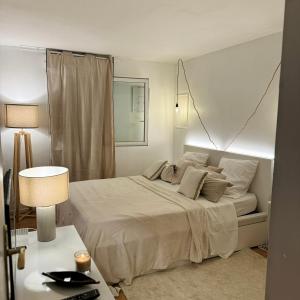 ein Schlafzimmer mit einem Bett und einem Tisch mit einer Lampe in der Unterkunft Canalisez-vous au Bord du Canal in Aubervilliers