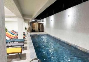 einen Pool mit Liegestühlen in einem Gebäude in der Unterkunft HOTEL CONTINENTAL in Abidjan