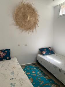 Zimmer mit 2 Betten und einem Kranz an der Wand in der Unterkunft Dar Soltan Oualidia in Oualidia