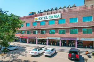 a building with cars parked in a parking lot at Hotel Cama in Chandīgarh