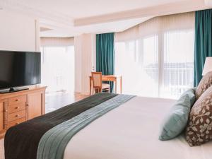 a bedroom with a large bed with a flat screen tv at Pullman Cairns International in Cairns