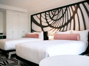 two beds in a room with a tree mural at Pullman Cairns International in Cairns