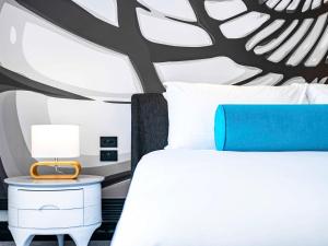 a bedroom with a white bed and a tree mural at Pullman Cairns International in Cairns