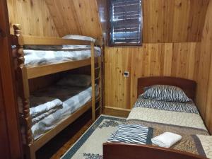 Cette chambre comprend deux lits superposés et un lit. dans l'établissement Vikendica "Oaza mira", à Gacko