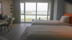 een hotelkamer met 2 bedden en een groot raam bij EVEN Hotel Yinchuan Yuehai, an IHG Hotel in Yinchuan