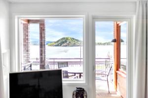 a living room with a view of the water through a window at Wright Apartments - Sørenga in Oslo