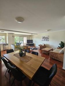 sala de estar con mesa de madera y sillas en Premium 3 bedroom River Front Location, en Rockhampton