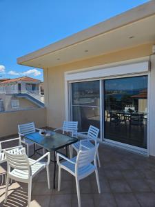 d'une terrasse avec une table et des chaises sur un balcon. dans l'établissement Mary's luxury apartment Elaia., à Elia Laconias