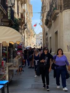 Eine Gruppe von Menschen, die eine Straße entlang gehen in der Unterkunft Casa Angelino in Syrakus