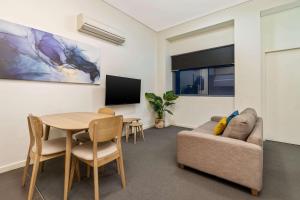 a living room with a couch and a table at Terminus Apartment Hotel, Ascend Hotel Collection in Newcastle