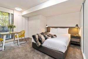 a bedroom with a bed and a desk and a table at Terminus Apartment Hotel, Ascend Hotel Collection in Newcastle