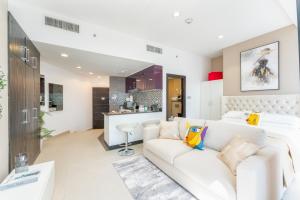 uma sala de estar com um sofá branco e uma cozinha em Cayan Tower Dubai Marina - By Home Of Choice no Dubai