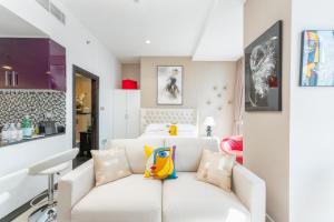 uma sala de estar com um sofá branco e uma cama em Cayan Tower Dubai Marina - By Home Of Choice no Dubai mais 28 fotografias