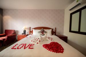a bed with red roses and a declaration of love at Nhà hàng - Khách sạn Sơn Nữ in Bak Kan