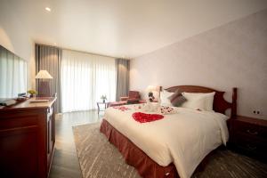 Un dormitorio con una cama grande con rosas rojas. en Nhà hàng - Khách sạn Sơn Nữ, en Bak Kan