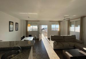 a living room with a couch and a sink at Apartamentos Cap y Corp in Alcossebre