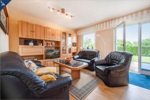 a living room with two leather chairs and a table at Am Schulberg Ferienhaus Albatros in Heringsdorf