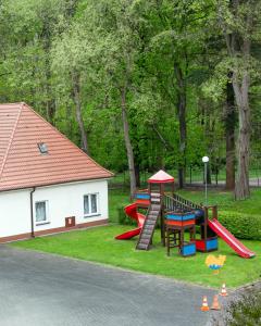 a playground with a slide in the grass at Dom Pracy Twórczej Politechniki Morskiej w Szczecinie in Świnoujście
