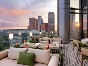 a rooftop patio with couches and a view of the city at Raffles Boston in Boston