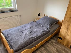 een bed met een houten frame in een slaapkamer bij Bungalow Neuss in Neuss