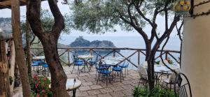 a patio with tables and chairs and a view of the ocean at Albergo La Conca Azzurra in Conca dei Marini