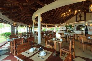 VOI Amarina Resort في نوسي بي: مطعم بطاولات وكراسي خشبية في الغرفة