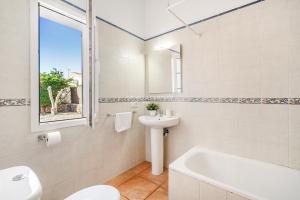a bathroom with a sink and a toilet and a bath tub at Villa CASSIA in Cala'n Porter