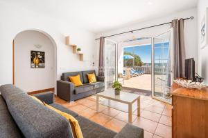 a living room with a couch and a table at Villa CASSIA in Cala en Porter +12 photos