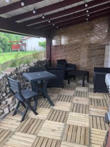 a patio with tables and chairs and a stone wall at Joli Appartement Proche Plage in Ahetze