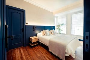1 dormitorio con 1 cama grande y puerta azul en GETXO ROOMS en Getxo