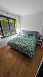 ヌイイ・シュル・セーヌにあるAdorable apartment in posh Neuillyのウッドフロアのベッドルーム1室(ベッド1台付)