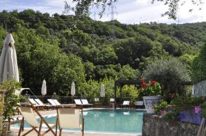 een zwembad met stoelen en een berg op de achtergrond bij Borgo San Francesco in Gioiosa Marea