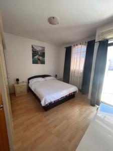 Schlafzimmer mit einem Bett und Holzboden in der Unterkunft Apartment Stipe in Bibinje