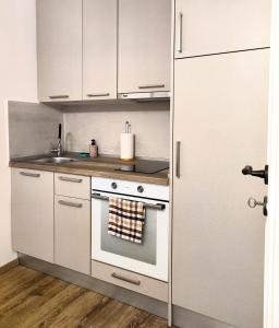 a white kitchen with a stove and a sink at Casa Contessina in Corfu Town