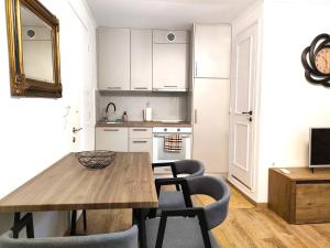 a kitchen and dining room with a wooden table and chairs at Casa Contessina in Corfu Town +9 photos