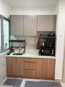 Bandar Baru BangiにあるHomestay Ohana Bangiのシンクと電子レンジ付きのキッチン