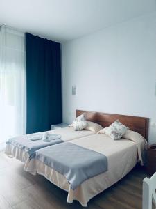 Dos camas en un dormitorio con paredes azules. en Costa De La Luz, en Huelva 28 fotos más