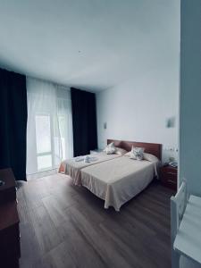 1 dormitorio con cama y ventana grande en Costa De La Luz en Huelva