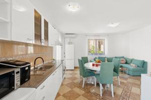 kuchnia i salon ze stołem i krzesłami w obiekcie Apartmani Lorena w Poreču