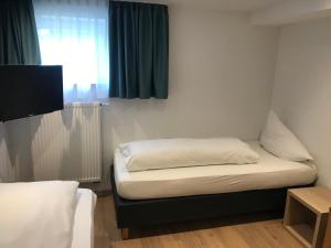 a small room with a bed and a window at Zimmerding in Erding