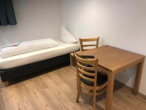 Cette chambre comprend une table, un lit, une table et une chaise. dans l'établissement Zimmerding, à Erding